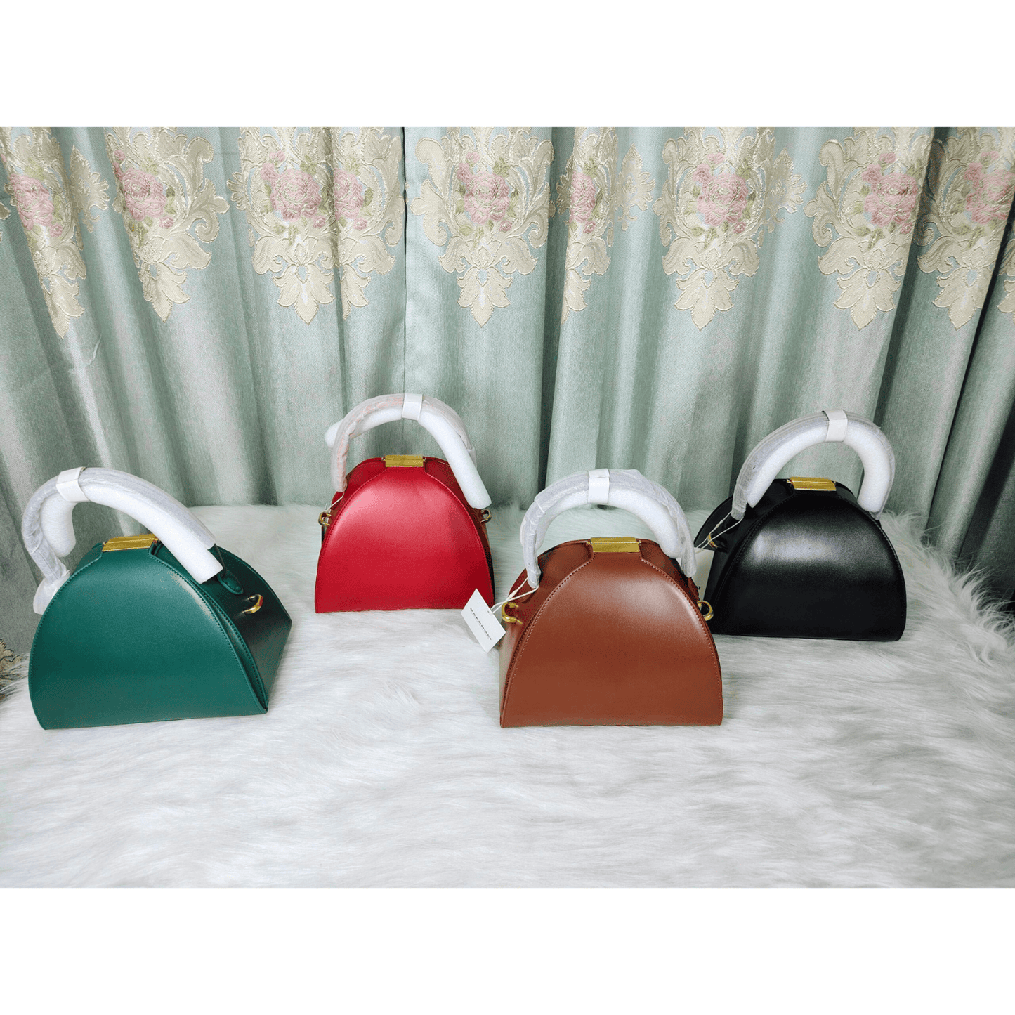 Four colorful pet carriers on a white surface with a patterned curtain