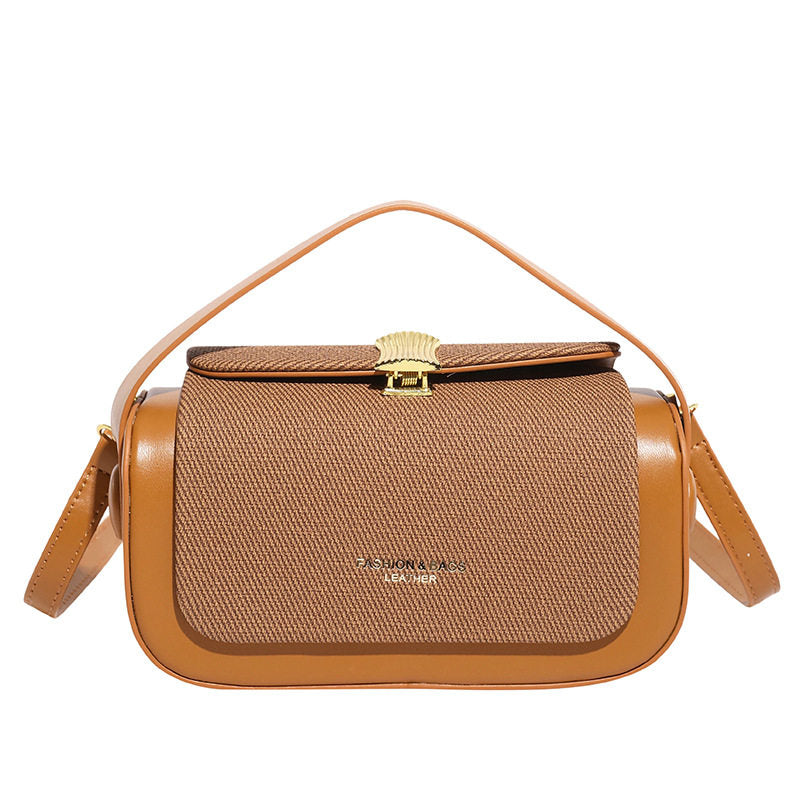 Brown handbag with gold accents on a white background