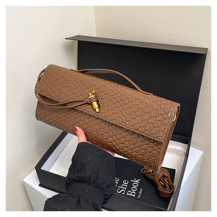 Brown woven handbag held above an open black box with a white interior.