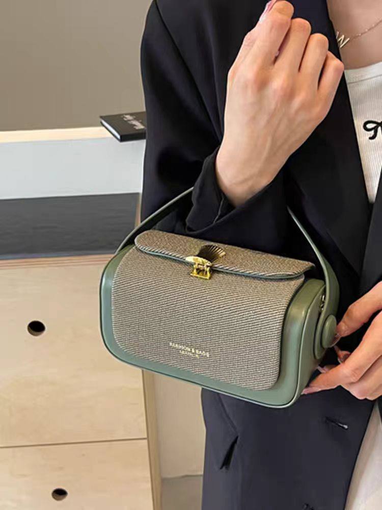 Person holding a green handbag with a textured surface