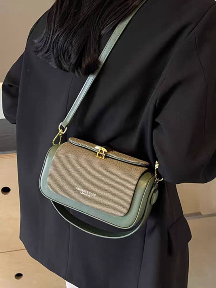 Person wearing a brown and green handbag with visible brand name.