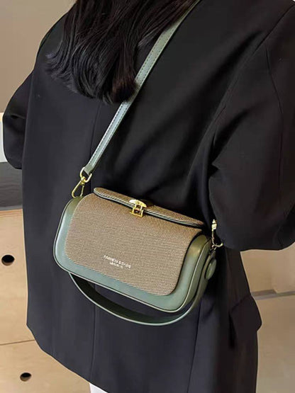 Person wearing a brown and green handbag with visible brand name.