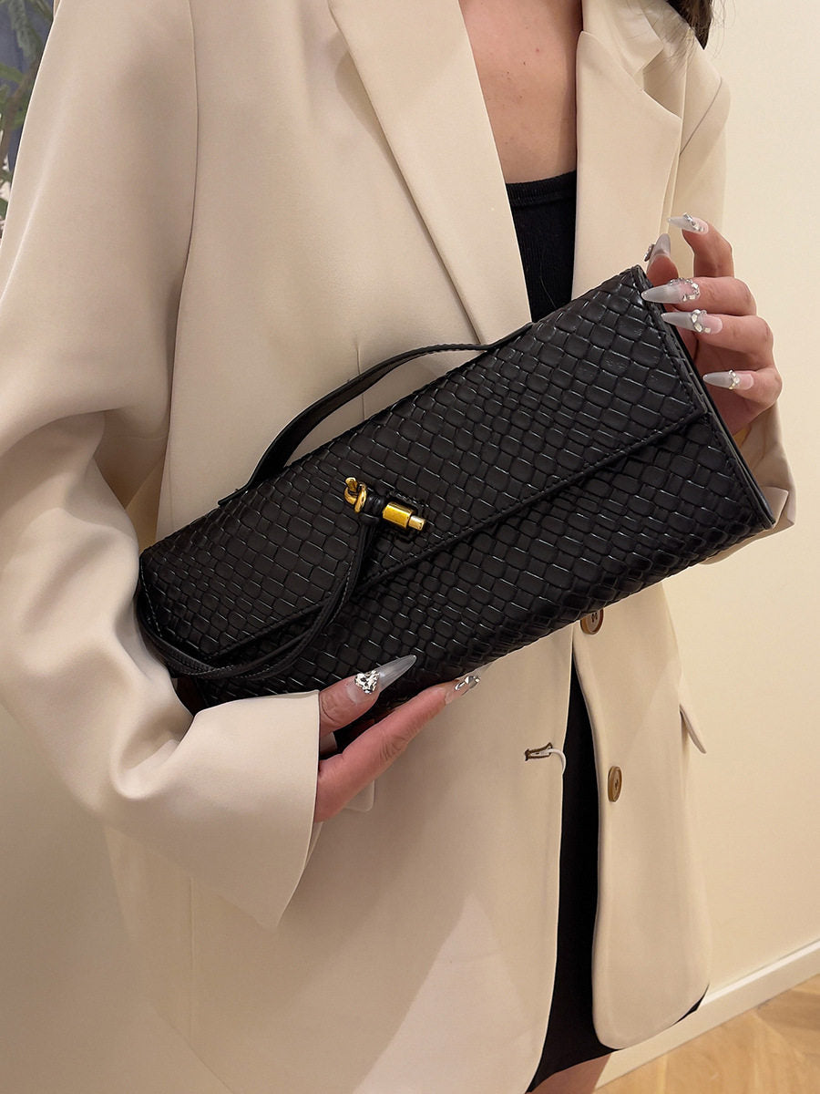 Person wearing a brown and green handbag with visible brand name.